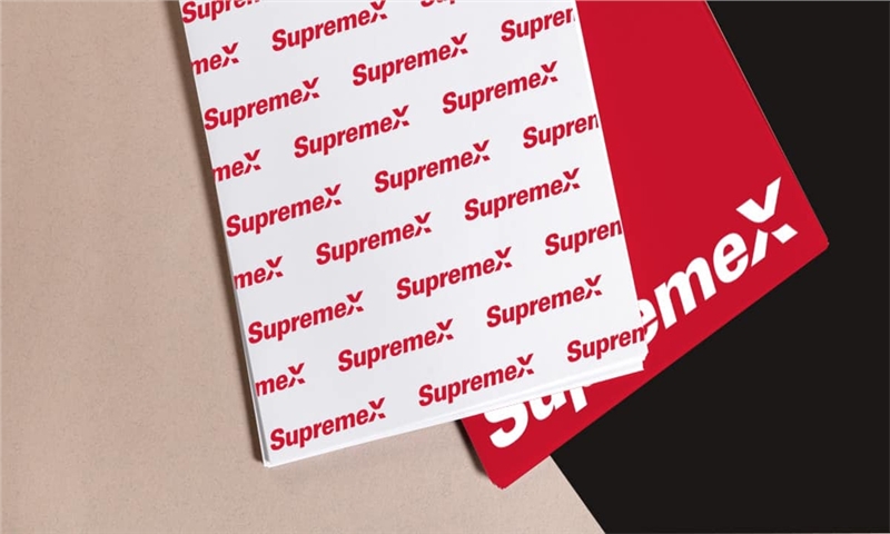 a close up of a red and white supreme logo on a sheet of paper